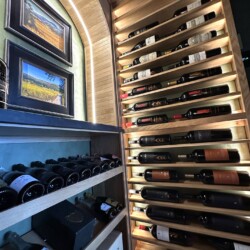 (6) A place for magnum-sized wine bottles is seen right near the wine cellar door and counter.